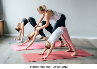 A trainer trains teenage girls to stand in a yoga pose. - Powered by Shutterstock