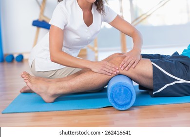 Trainer working with man on exercise mat in fitness studio - Powered by Shutterstock