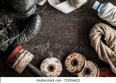 Training accessories. Old boxing glove, boxing wrap, dumbbell, towel and water bottle. Cares about a body. Sport concept. Vintage retro style. Top view. - Powered by Shutterstock