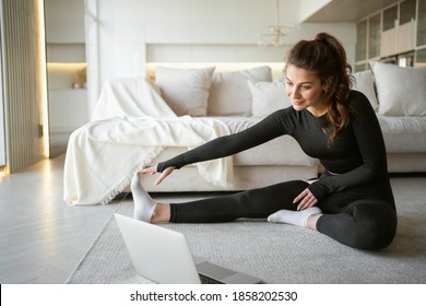 Training Exercises Stretching In Front Of An Online Trainer At Home. Fitness Is A Sport To Promote Health And A Strong Body. Cozy Apartment In Bright Colors.