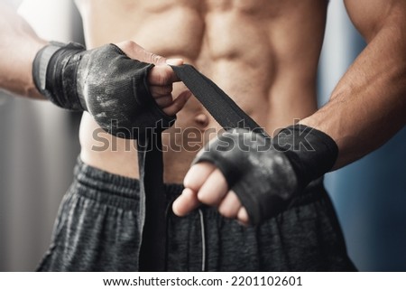 Training, fitness and boxing man prepare for workout or match at gym or fitness center with hand wrap. Closeup of athletic boxer getting ready for strength, cardio and endurance kickboxing challenge
