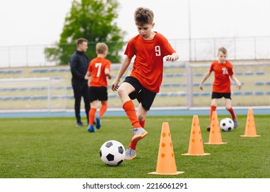 Training football session for children on soccer camp. Boy in children's soccer team on training. Kids practicing outdoor with a soccer balls. Young boy improving dribbling skills. Training with cones - Shutterstock ID 2216061291