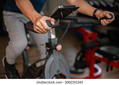 Training gym concept a male teenager doing cardio workout on cycling machine in the gym as his healthy routine. - Shutterstock ID 2002331345