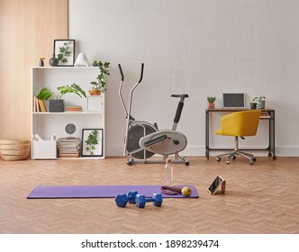 Training at home concept, interior, decorative sport in the room with gym fitness exercise purple mat, dumbbell and bicycle.