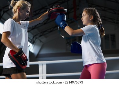 Training In Kickboxing Techniques. Junior Female Kickboxer Workout With Personal Coach At Sports Gym, Indoors. Concept Of Studying, Challenges, Sport, Hobbies, Competition.