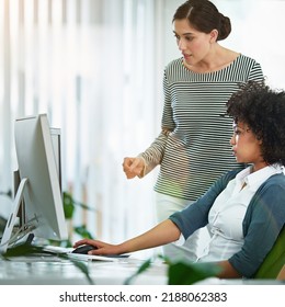 A Training Manager Talking About Online Collaboration Project With Intern Assistant Looking On A Desktop Monitor Screen. Business Woman Discussing Latest Social Media Strategy Or Analyzing Seo