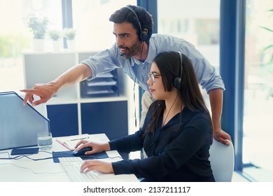 Training A New Employee About Delivering Quality Service. Cropped Shot Of Two Call Centre Agents Working Together In An Office.