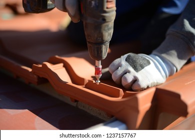 Training In Roofing Trade- Professional Roofing Company Is Building Big New Roof With Red Tiles - Close-up Of Screwing With Cordless Screwdriver Tools, Roof Maintenance