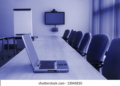 Training Room With Desk Chairs Laptop Video Conferencing Equipment And White Board