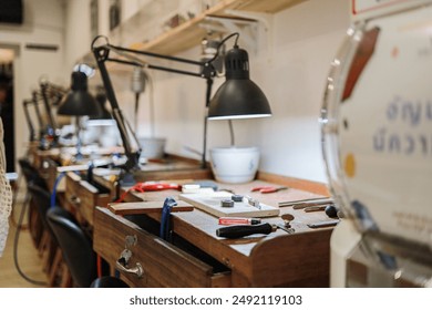 Training table with lamp and tools in jewelry making school - Powered by Shutterstock