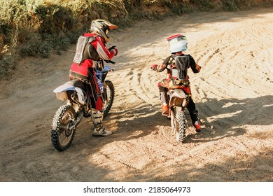 Training with trainer. Live shot of junior sportsman, motorcyclist riding on motorbike at hot summer day, outdoors. Motocross sport, competition, male hobby, energy and ad