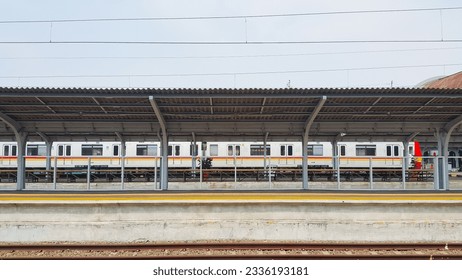 The trains stop at the station. An empty train platform. Clear blue sky.