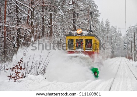 Tram with snow blower clears snow on public tram railways during a blizzard