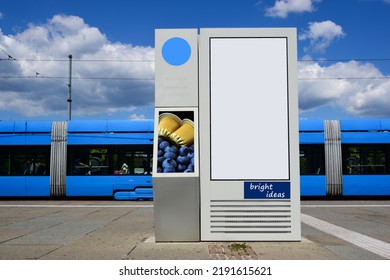 Tram Stop In Urban Setting. Ad Panel. Empty Blank Poster And Advertising Billboard Sign. Mock-up Base. Raster Type Business Communication Placeholder. Sample Image. Modern Blue Tram In The Background