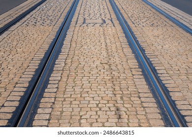 Tram tracks run down a cobblestone street. - Powered by Shutterstock