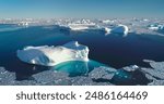 Tranquil Arctic scene icebergs floating blue ocean. Broken sea ice under bright blue sky sunlight. Glacier melting in polar summer, aerial. Ecology, melting ice, climate change, global warming concept