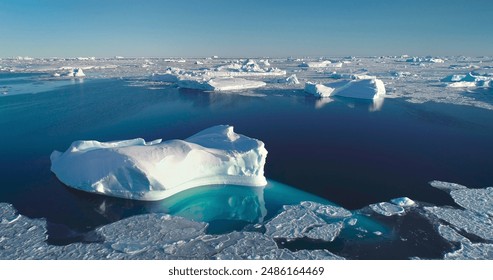 Tranquil Arctic scene icebergs floating blue ocean. Broken sea ice under bright blue sky sunlight. Glacier melting in polar summer, aerial. Ecology, melting ice, climate change, global warming concept - Powered by Shutterstock