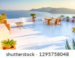 Tranquil Atmosphere at Open Air Terrace Restaurant in Beautiful Oia Village on Santorini Island in Greece in Front of Volcanic Caldera Mountain.Horizontal Image