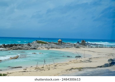 Tranquil Beach Scene with Turquoise Clear Waters, Rolling Waves, Sandy Beach and Rocky Terrain at El Mirador Beach in Cozumel Mexico - Powered by Shutterstock