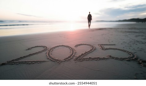 A tranquil beach at sunset with the year 2025 written in the sand, capturing a reflective moment as a solitary figure strolls along the shore. Perfect for themes of hope and new beginnings. - Powered by Shutterstock