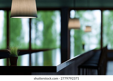 A tranquil cafe interior featuring a hanging lamp, a small potted plant, and large windows overlooking lush green trees.