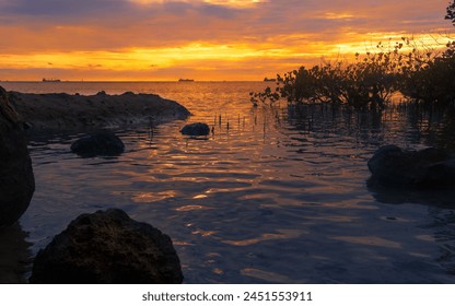 Tranquil coastal sunset with rocks and dramatic sky - Powered by Shutterstock