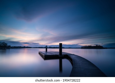 A tranquil dusk at a pontoon for swimmers in a lake.