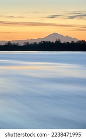 Tranquil Fraser River Dawn Vertical. Quiet early morning dawn on the Fraser River, British Columbia. Mt. Baker on the horizon.

                                - Shutterstock ID 2238471995