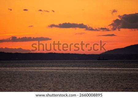 A tranquil horizontal landscape captures the dramatic colors of a sunset over the beach at Port Seton, Scotland
