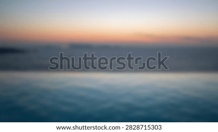 A tranquil infinity pool reflects the soft hues of a pastel sunset over the vast ocean, creating a peaceful and luxurious atmosphere.