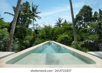 A tranquil infinity pool seamlessly blends with the vibrant greenery of Bali's lush landscape. Perfect for showcasing luxury getaway destinations.