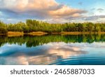 A tranquil lake surrounded by lush greenery, with vibrant water reflecting a dramatic sky a serene scene in nature