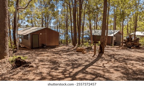 Tranquil lakeside cabins surrounded by lush forest in Western Australia. Ideal for nature lovers seeking serene retreats, outdoor adventures, and camping escape. Travel stock photography. - Powered by Shutterstock