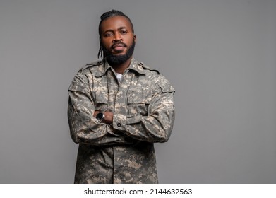 Tranquil Male In A Khaki Uniform Standing By The Wall