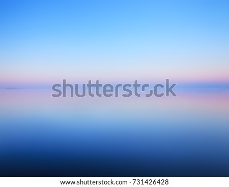 Tranquil minimalist landscape with smooth surface of the lake with calm water with horizon with clear blue sky in twilight, simple beautiful calm natural blue background