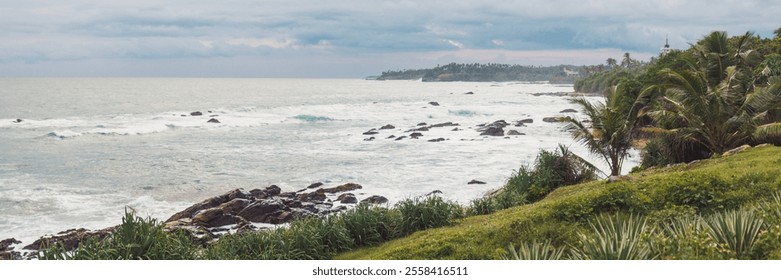 A tranquil panoramic banner showcasing a rocky shoreline and lush greenery along a scenic coast. The waves gently crashing against the rocks under an overcast sky create a peaceful ambiance, making it - Powered by Shutterstock