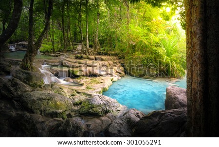 Tranquil and peaceful nature background of beautiful river stream flowing through natural cascades and wet stones with sunlight shining gently 