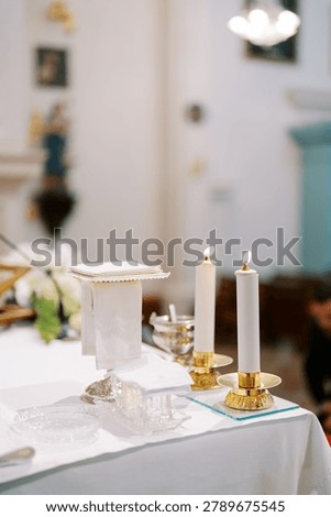 Tranquil religious setting featuring candles and colorful stained glass