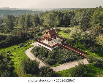A tranquil religious structure surrounded by lush greenery, located in Israel, offers a serene escape.