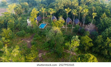 Tranquil resort amidst lush greenery in Sri Lanka. A serene resort surrounded by vibrant trees features cozy cottages and a refreshing pool, offering a peaceful retreat in Sri Lanka's nature. - Powered by Shutterstock