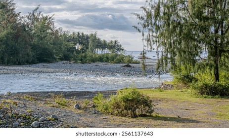 tranquil river flows through a rocky bed towards the ocean.