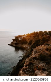 A Tranquil Scene Of Beautiful Landscape In Ibiza Overlooking Turquoise Waters And White Sand Beach.