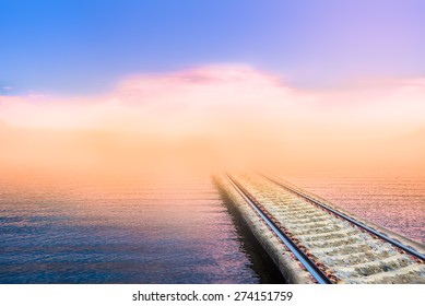 tranquil scene of a railroad to nowhere in the sea with fog