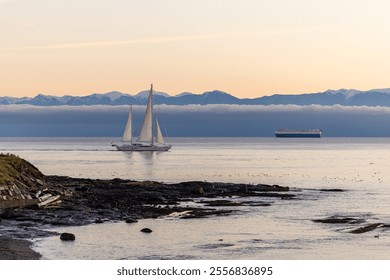 A tranquil scene of a sailing boat under a beautiful sunset in Victoria, Vancouver Island, with mountains in the background. Perfect depiction of nature’s serene beauty along the Pacific coast. - Powered by Shutterstock