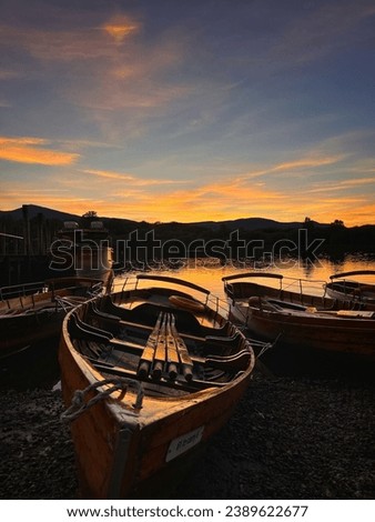 A tranquil scene of small boats docked at a lake at sunset
