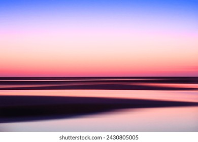 Tranquil seascape with pastel twilight colors and serene water reflections.