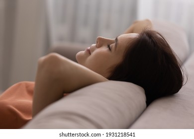Tranquil serenity. Healthy calm teen female lean back on cozy couch at living room rest with happy face do breathing exercise keep eyes closed. Peaceful young woman chill relax at home on lazy weekend