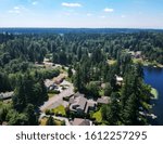 Tranquil Shady Lake on a bright clear day in summertime with trees reflecting in the water a blue sky and white clouds with lily pads dockside in Renton King County Washington State