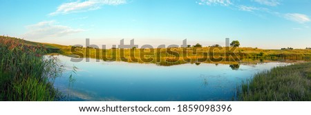 Tranquil summer landscape with river at sunset