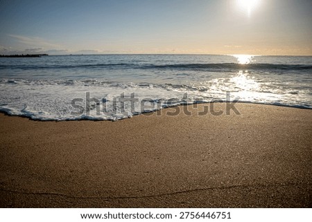 The tranquil sunrise and the lapping waves on the sandy beach of Kawarago Beach